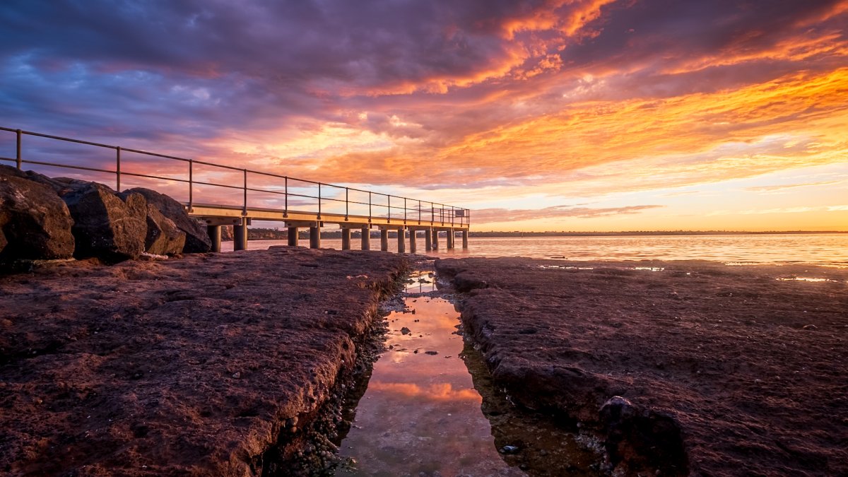 A golden sunrise over the ocean with warm light reflecting off the water