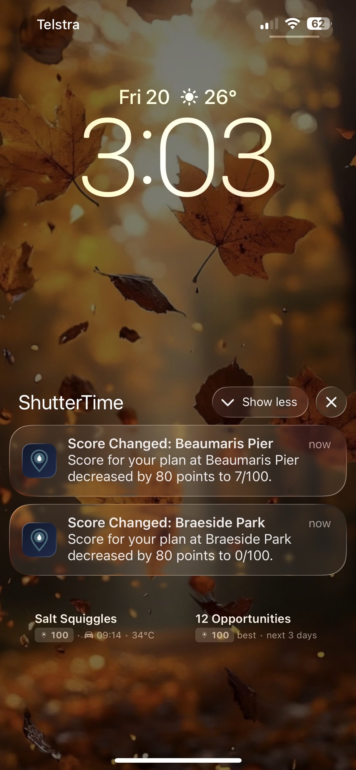 iPhone lock screen showing two ShutterTime score change notifications — scores decreased for Beaumaris Pier and Braeside Park plans — with lock screen widgets